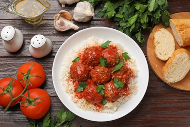 Photo of Tasty meatballs with sauce, rice and products on wooden table, flat lay