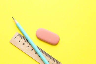 Photo of Eraser, pencil and ruler on yellow background, top view. Space for text