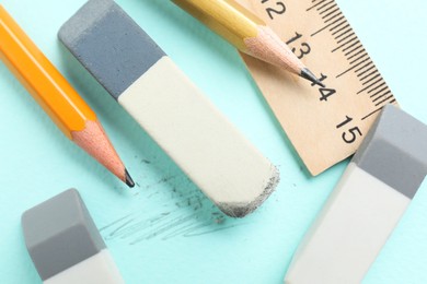 Photo of Erasers, pencils and ruler on light blue background, flat lay