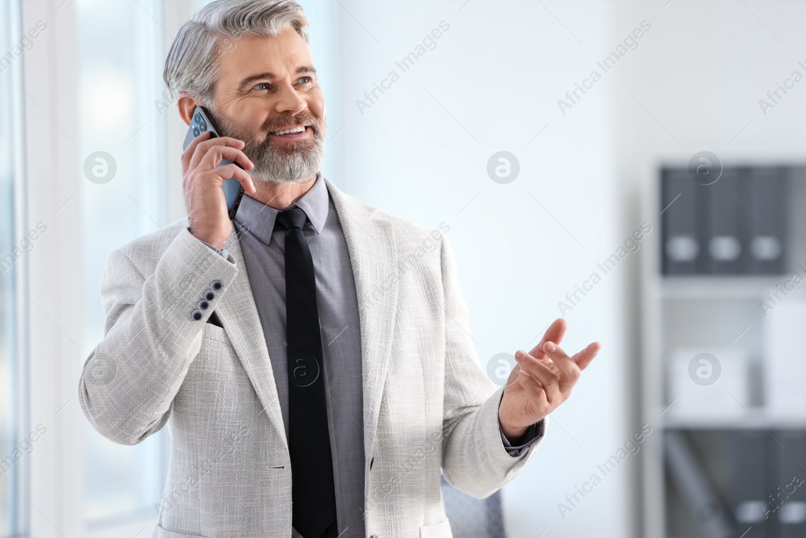 Photo of Banker talking on smartphone in office, space for text