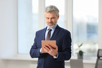 Portrait of banker with tablet in office