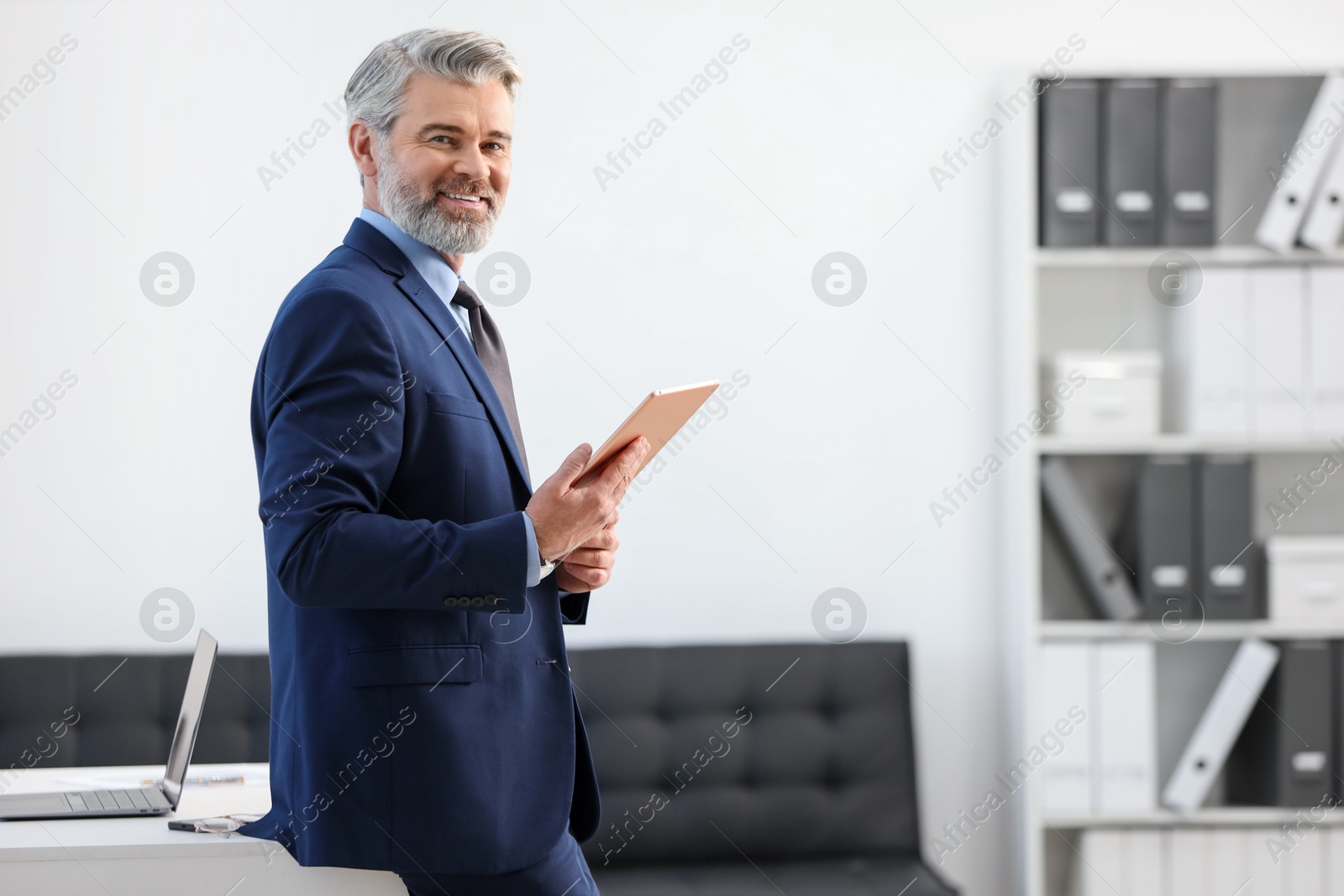 Photo of Banker with tablet near desk in office, space for text