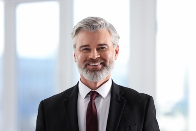 Portrait of happy banker with jacket in office