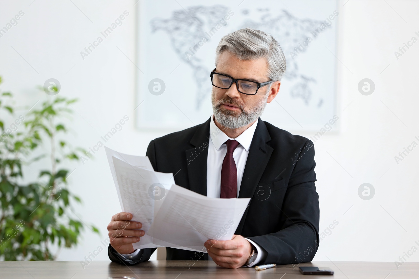 Photo of Portrait of banker with documents at desk in office