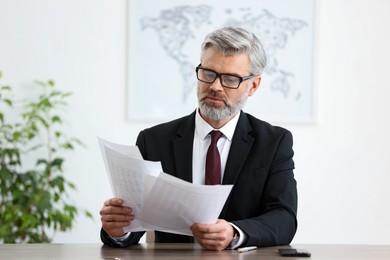 Photo of Portrait of banker with documents at desk in office