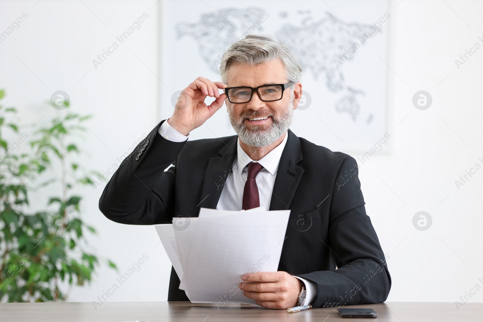 Photo of Portrait of banker with documents at desk in office