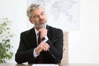 Photo of Banker with glasses at desk in office, space for text