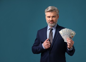 Photo of Banker with dollar banknotes on blue background, space for text