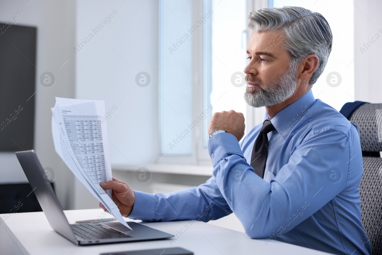 Photo of Banker with documents at desk in office