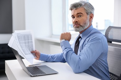 Photo of Banker with documents at desk in office