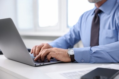 Photo of Banker working on laptop at desk in office, closeup