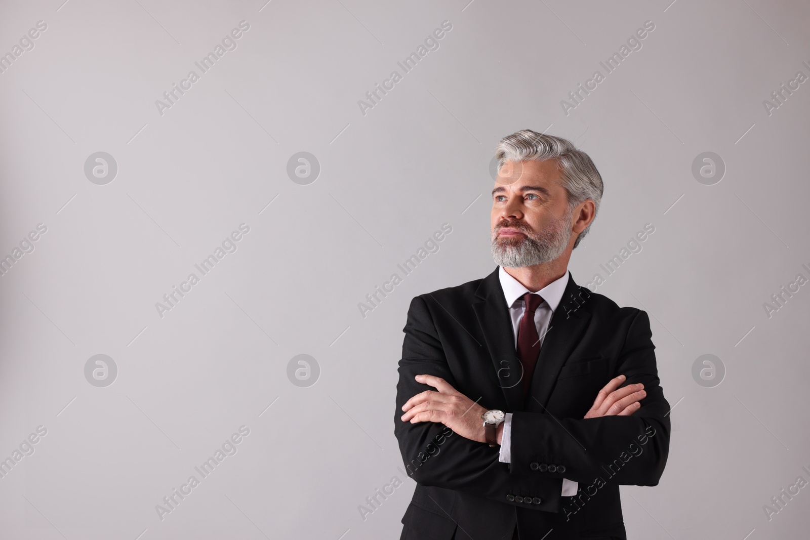 Photo of Portrait of banker with crossed arms on grey background, space for text