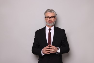 Portrait of banker in glasses on grey background