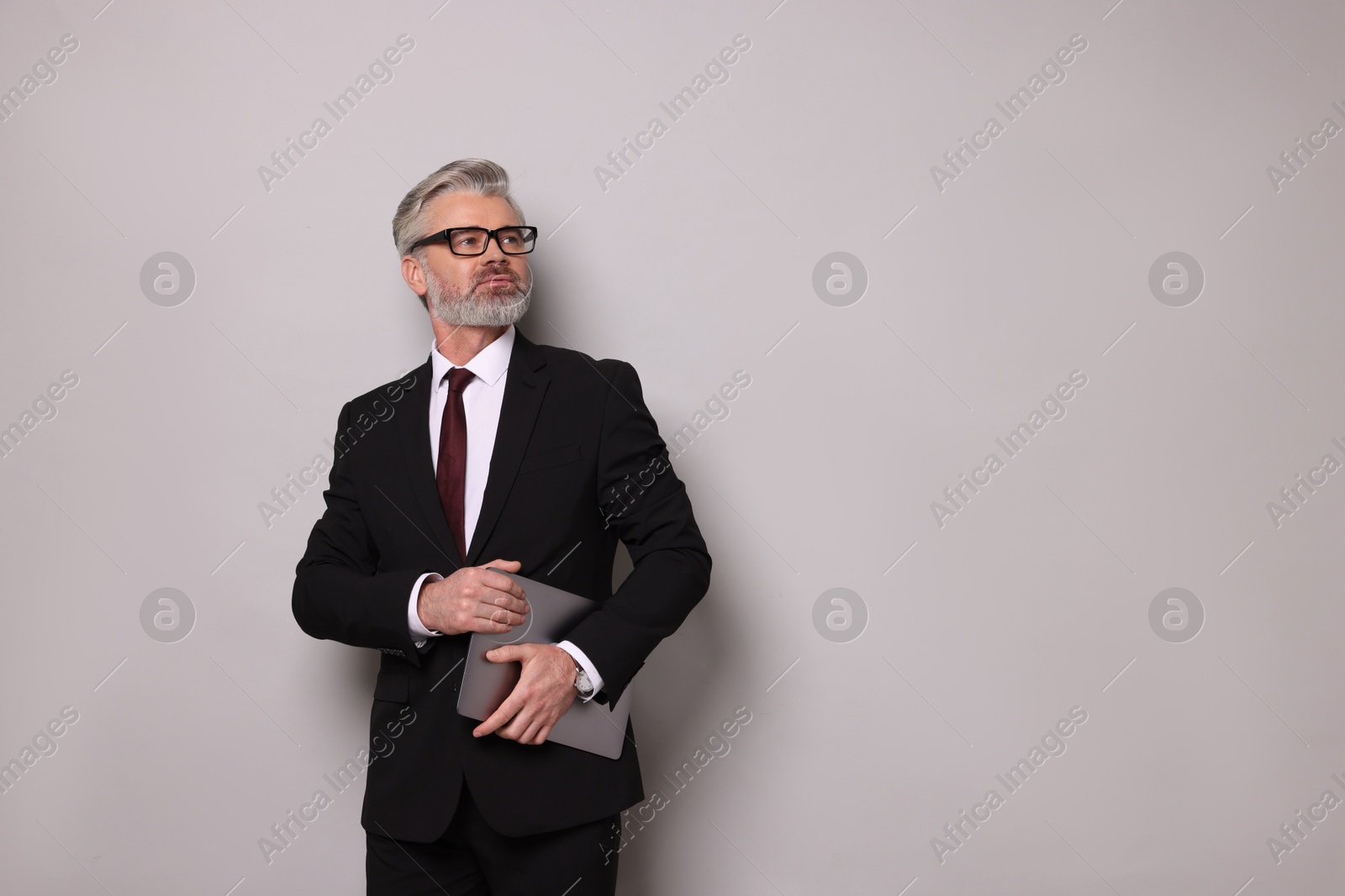 Photo of Portrait of banker with laptop on grey background, space for text