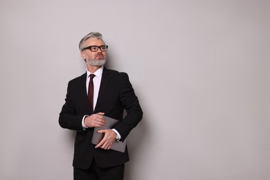 Photo of Portrait of banker with laptop on grey background, space for text