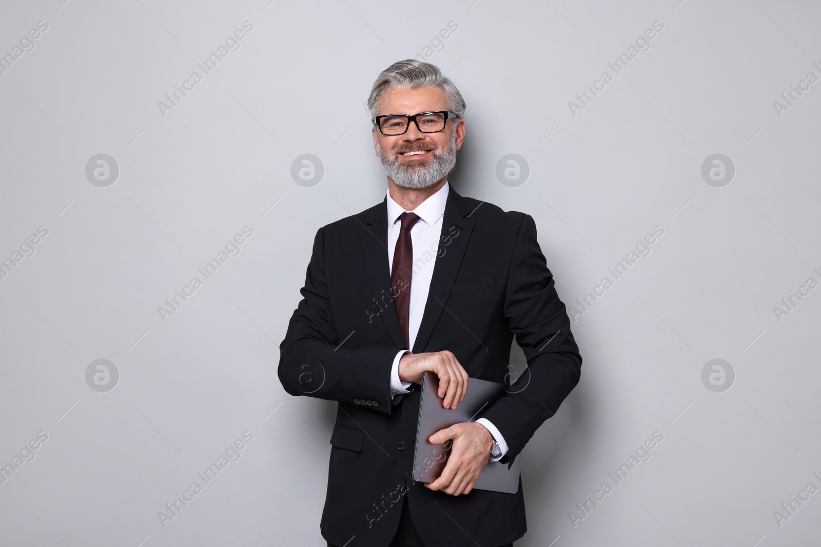 Photo of Portrait of banker with laptop on grey background