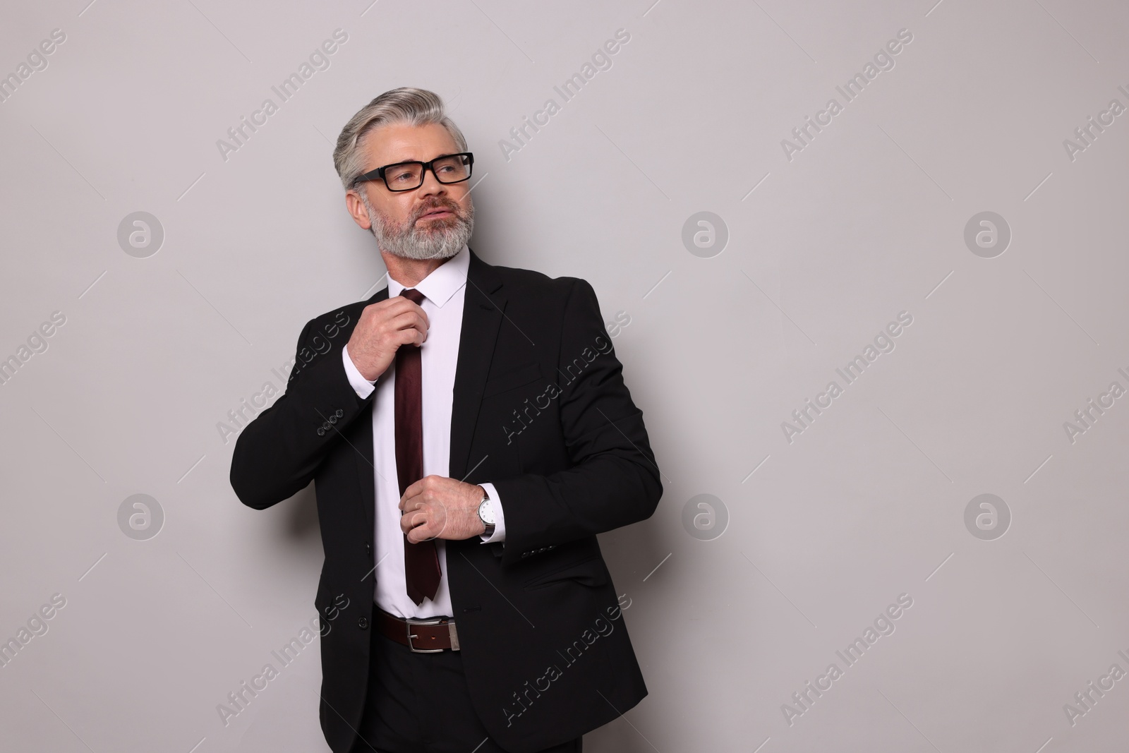 Photo of Portrait of banker in jacket on grey background, space for text