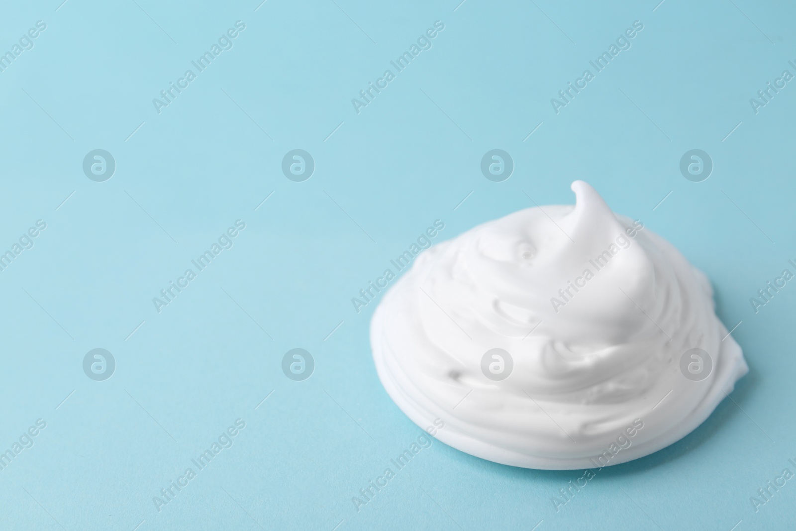 Photo of Sample of fluffy foam on light blue background, space for text