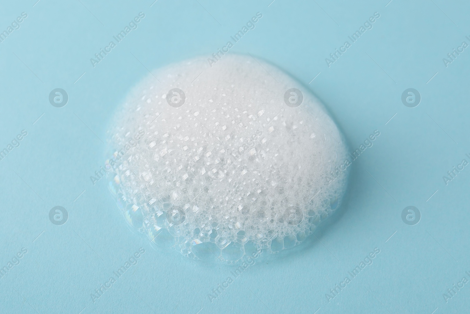 Photo of Sample of fluffy foam on light blue background, closeup