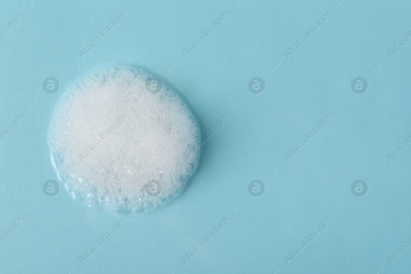 Photo of Sample of fluffy foam on light blue background, top view. Space for text