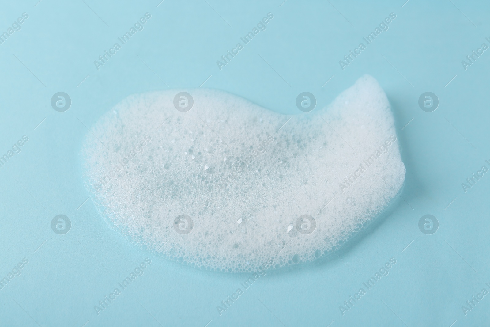 Photo of Sample of fluffy foam on light blue background, closeup