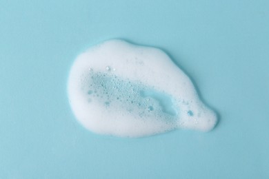 Photo of Sample of fluffy foam on light blue background, top view