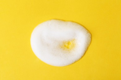 Photo of Sample of fluffy foam on orange background, top view