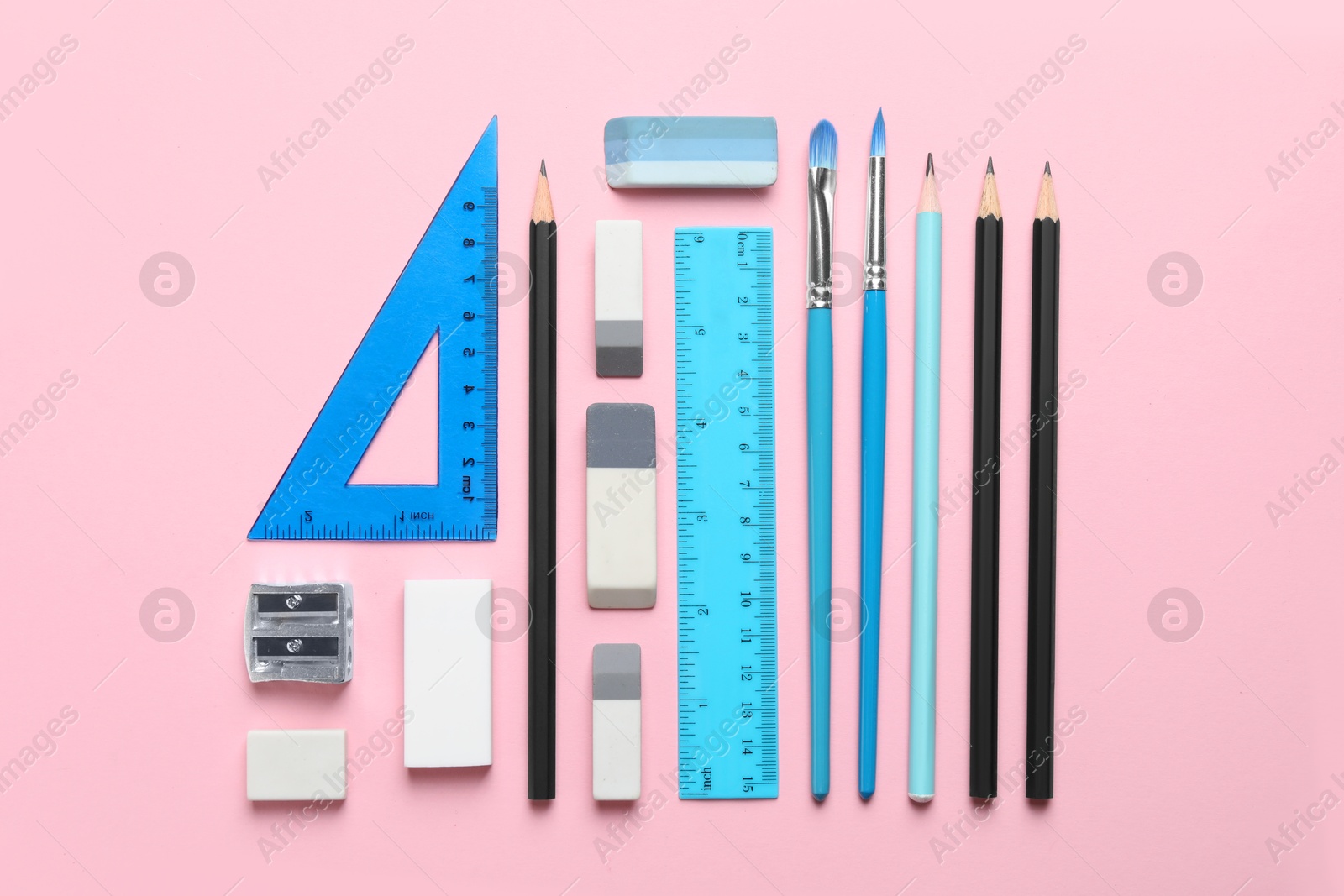 Photo of Erasers and other different stationery on pink background, flat lay