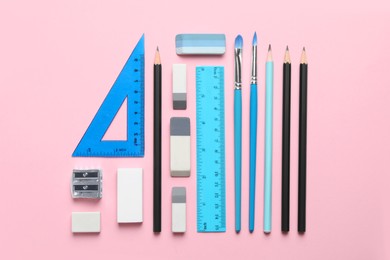 Photo of Erasers and other different stationery on pink background, flat lay