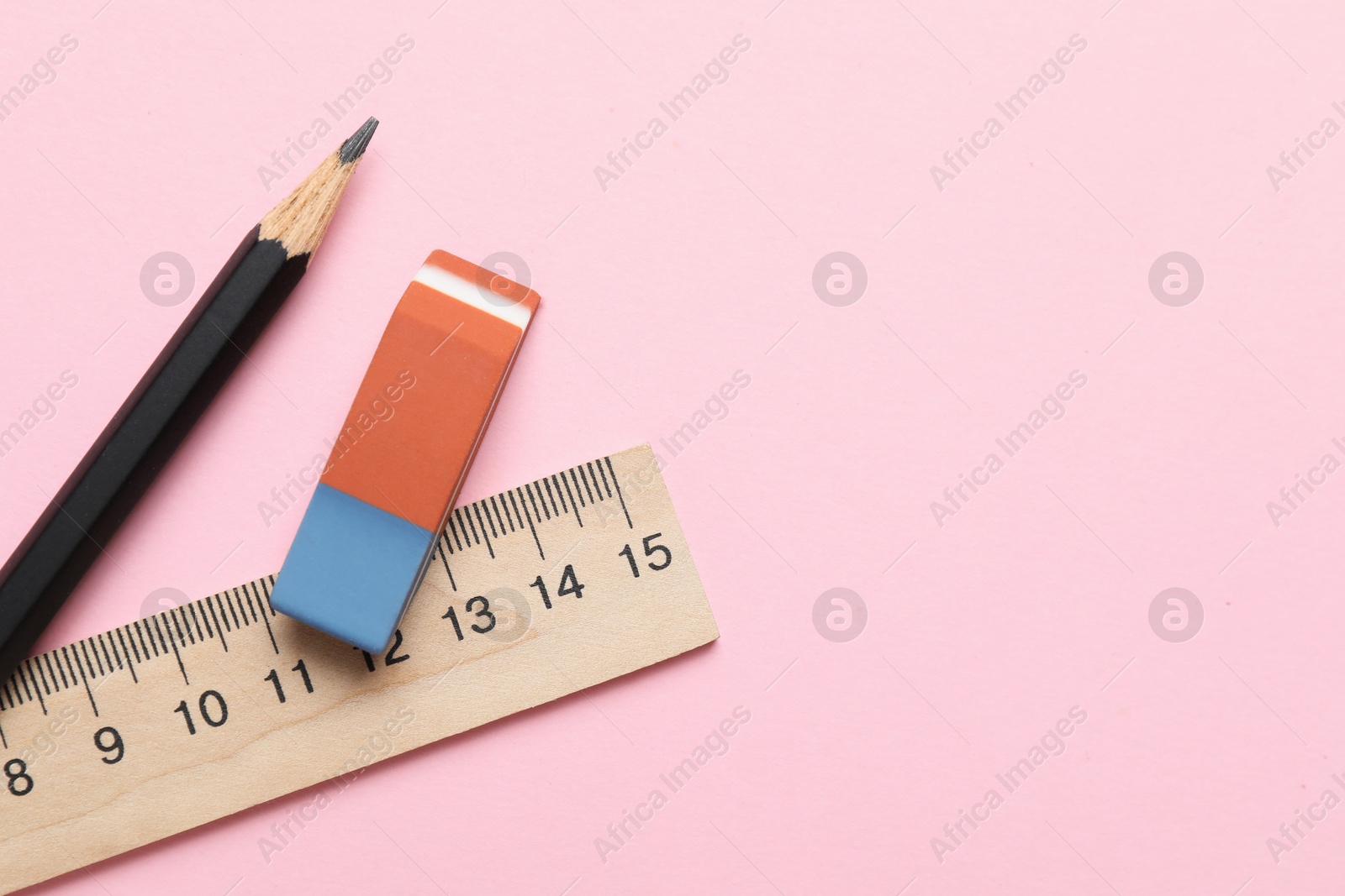 Photo of Eraser, ruler and pencil on pink background, flat lay. Space for text