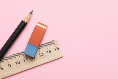 Photo of Eraser, ruler and pencil on pink background, flat lay. Space for text