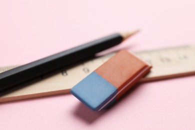 Photo of Eraser, ruler and pencil on pink background, closeup