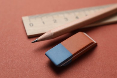 Photo of Eraser, ruler and pencil on brown background, closeup. Space for text