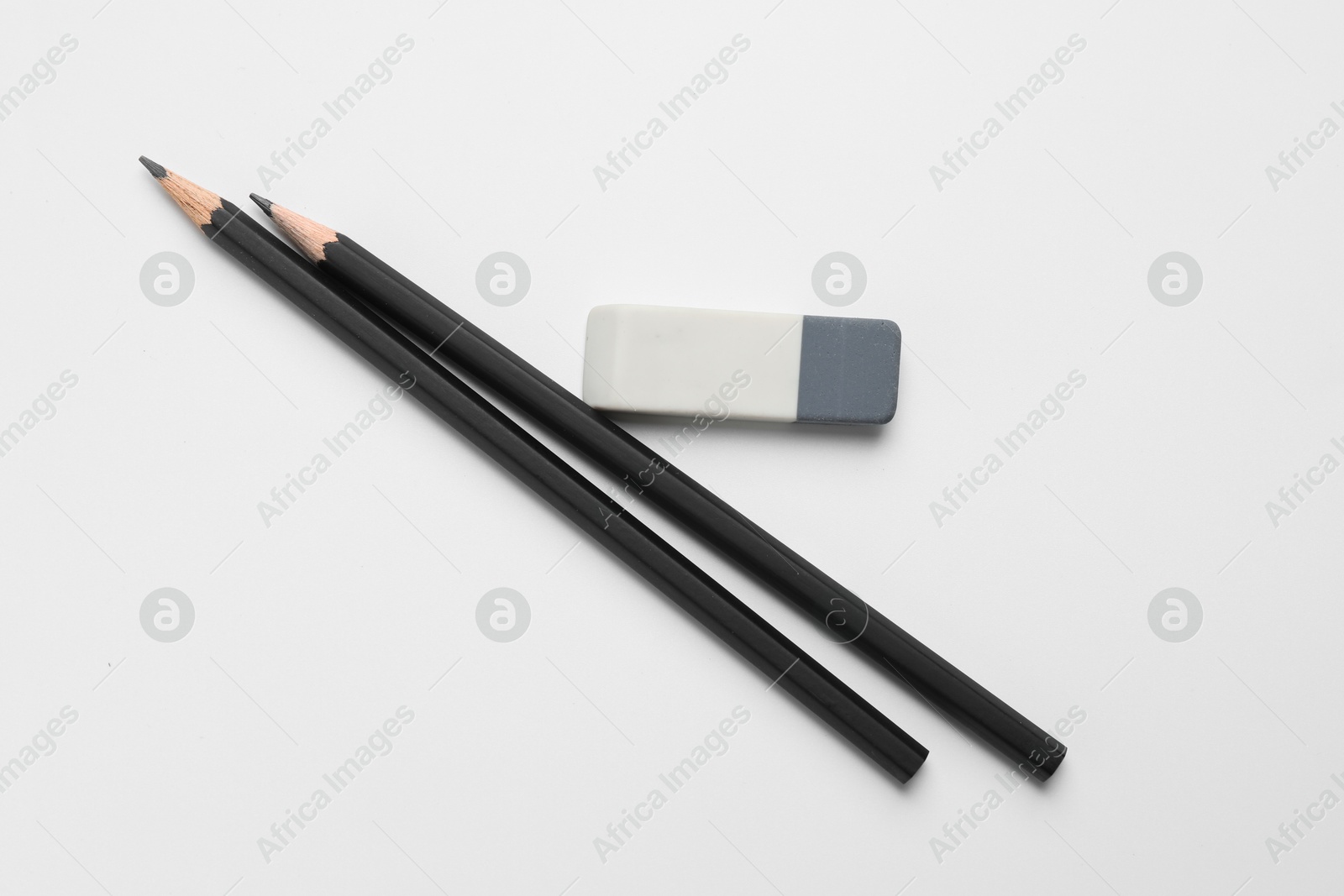 Photo of Eraser and pencils on white background, flat lay