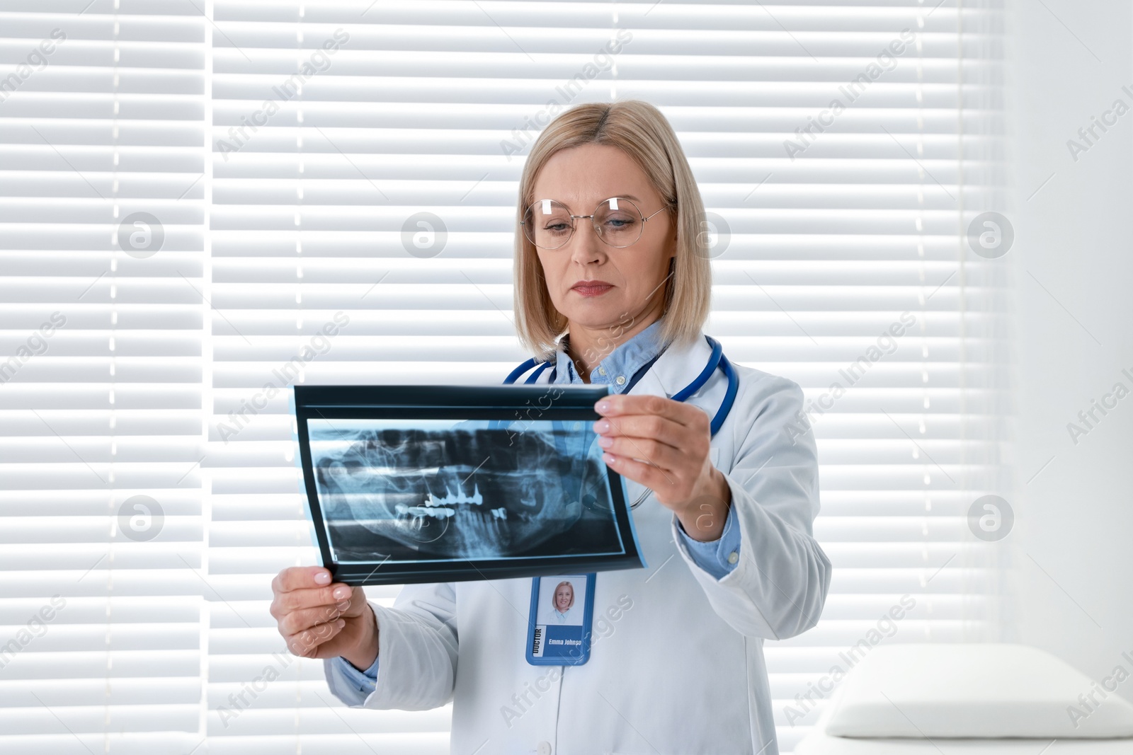 Photo of Doctor with glasses examining x-ray picture in clinic