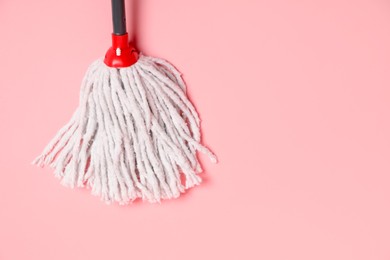 Photo of String mop on pink background, top view. Space for text