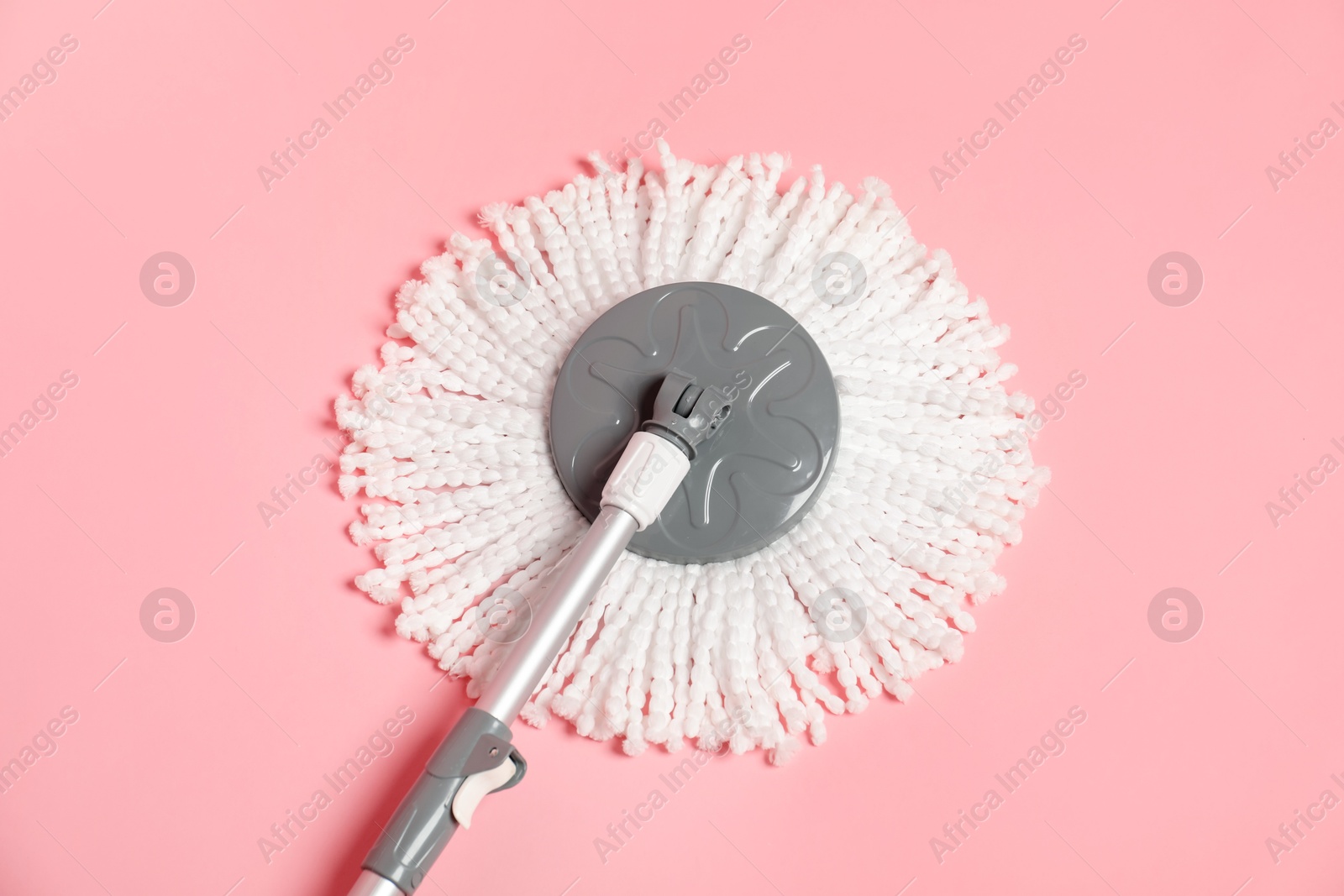 Photo of String mop on pink background, above view