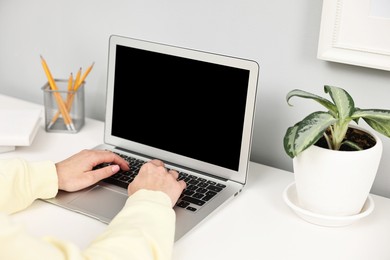 Photo of Woman working on computer at desk indoors, closeup