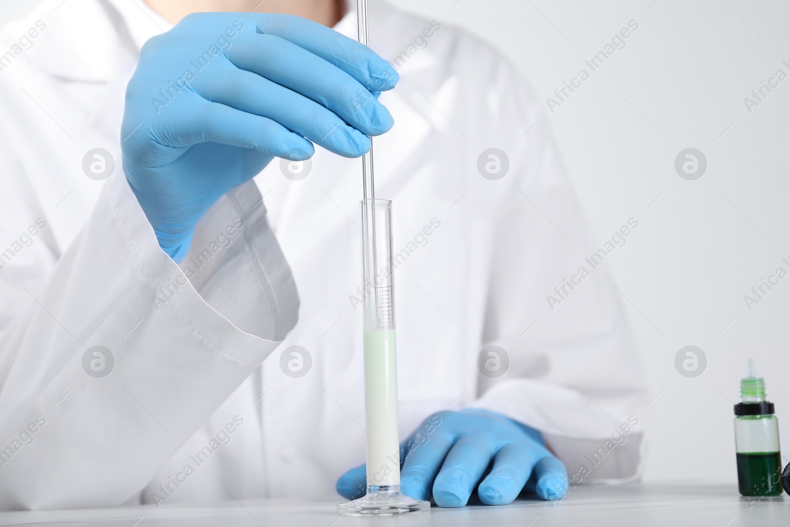 Photo of Laboratory testing. Scientist working with test tube at white table, closeup