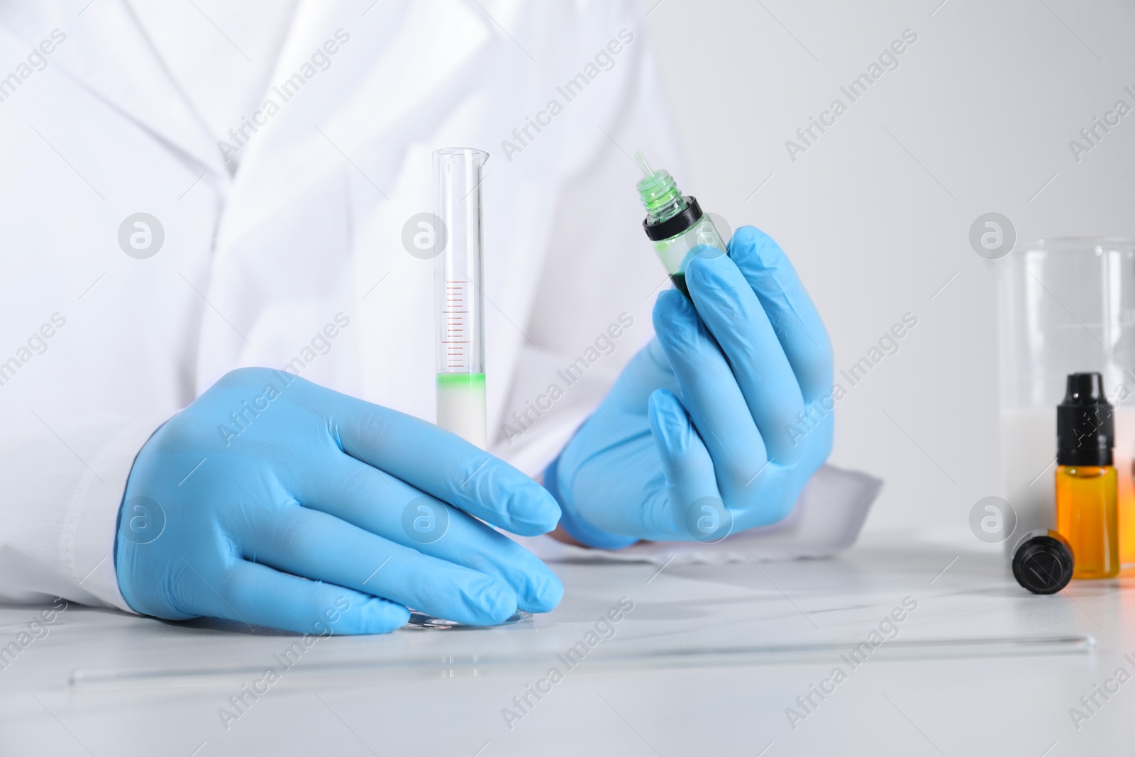 Photo of Laboratory testing. Scientist working with test tube at white marble table, closeup