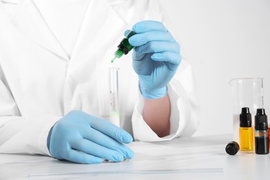 Photo of Laboratory testing. Scientist working with test tube at white marble table, closeup