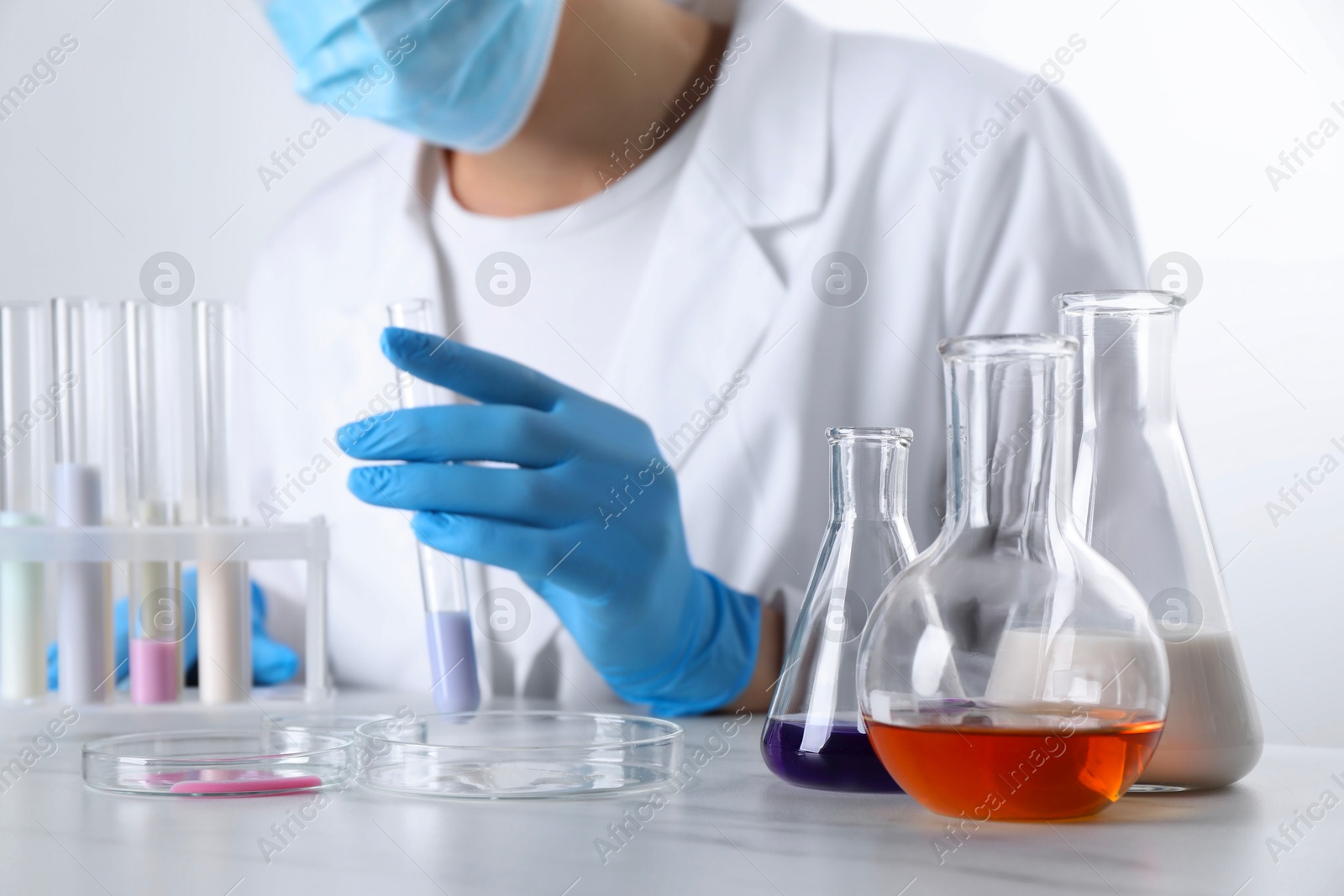 Photo of Laboratory testing. Scientist working with glassware at white marble table, closeup