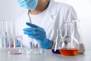 Photo of Laboratory testing. Scientist working with glassware at white marble table, closeup