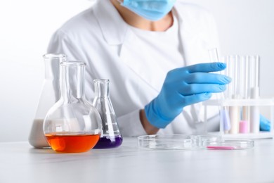 Photo of Laboratory testing. Scientist working with glassware at white marble table, closeup