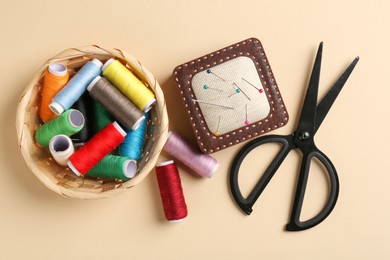 Photo of Different sewing supplies on beige background, flat lay