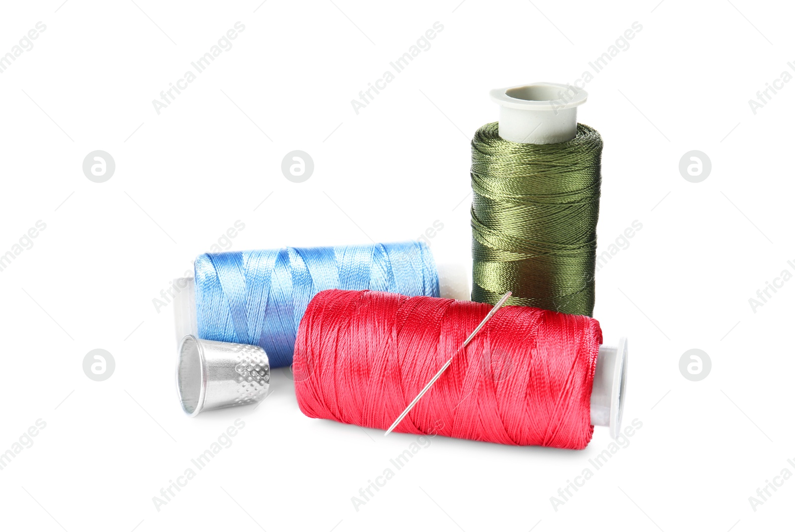 Photo of Spools of thread and other sewing supplies isolated on white