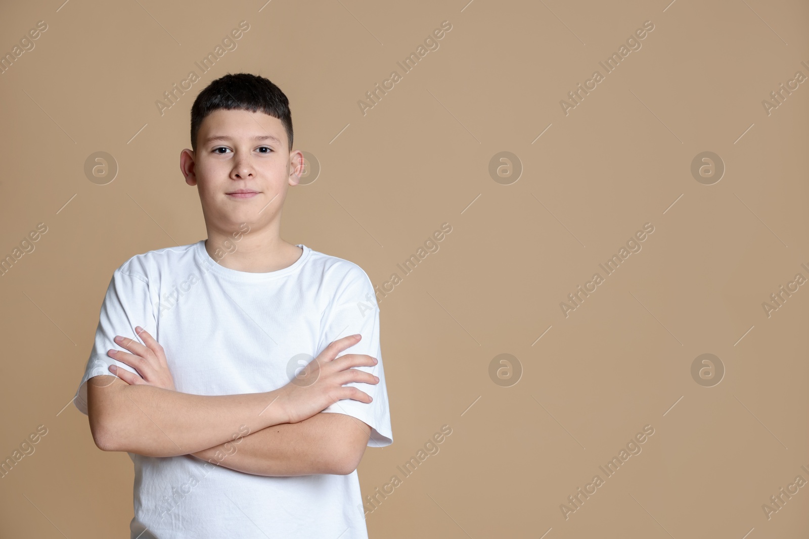 Photo of Portrait of teenage boy on beige background, space for text