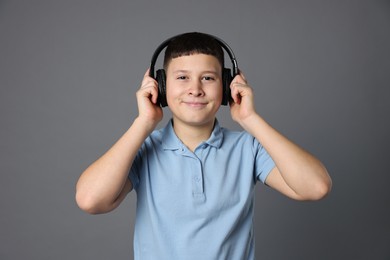 Photo of Portrait of teenage boy in headphones on grey background