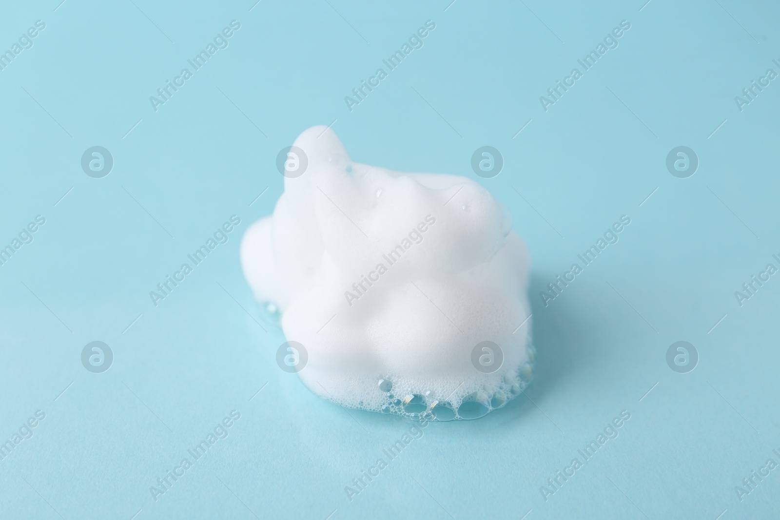 Photo of Sample of fluffy foam on light blue background