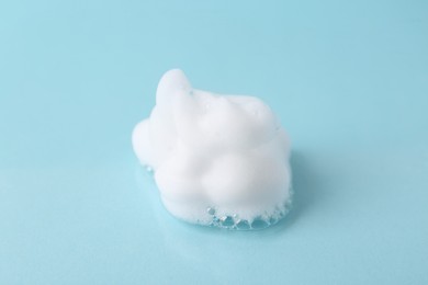 Photo of Sample of fluffy foam on light blue background